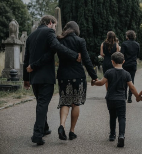 Trauernde Familie bei einer Beisetzung auf dem Friedhof